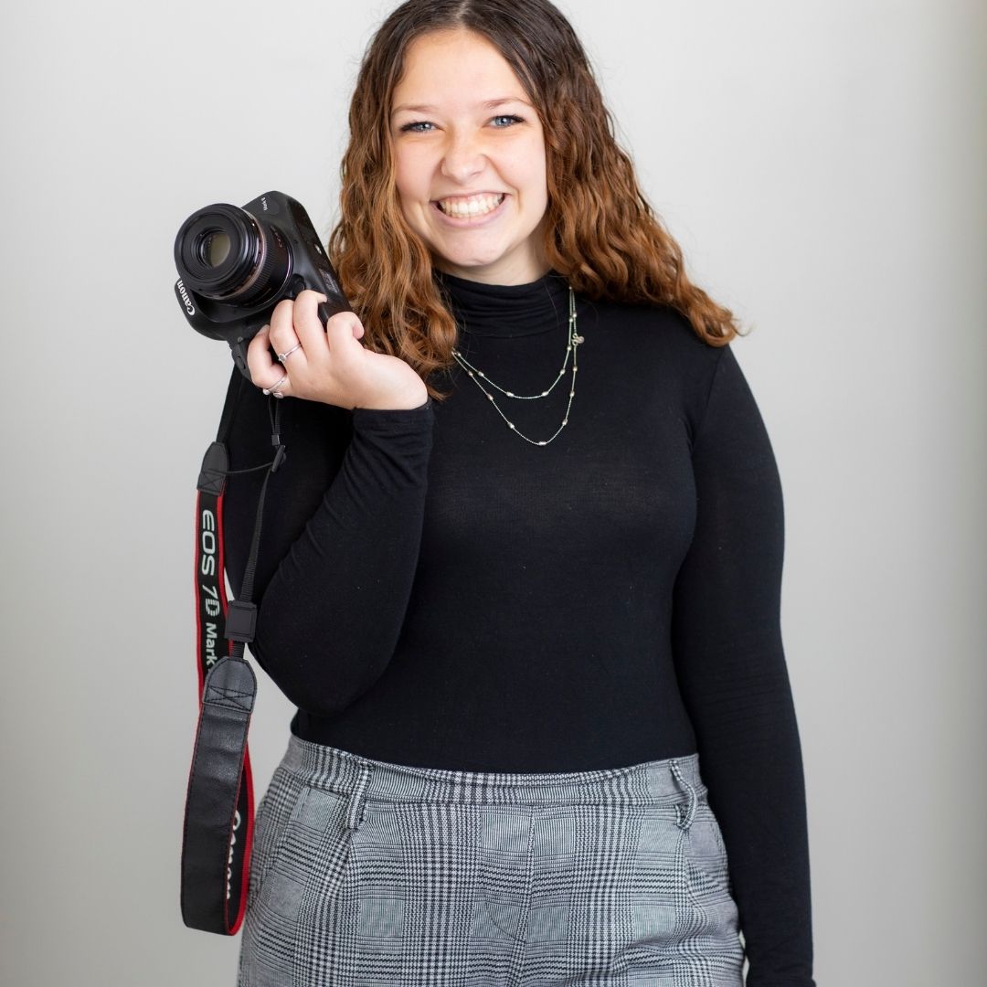 Jillian Lawrence holding a Canon camera over her shoulder, embodying creativity at Consociate Media.